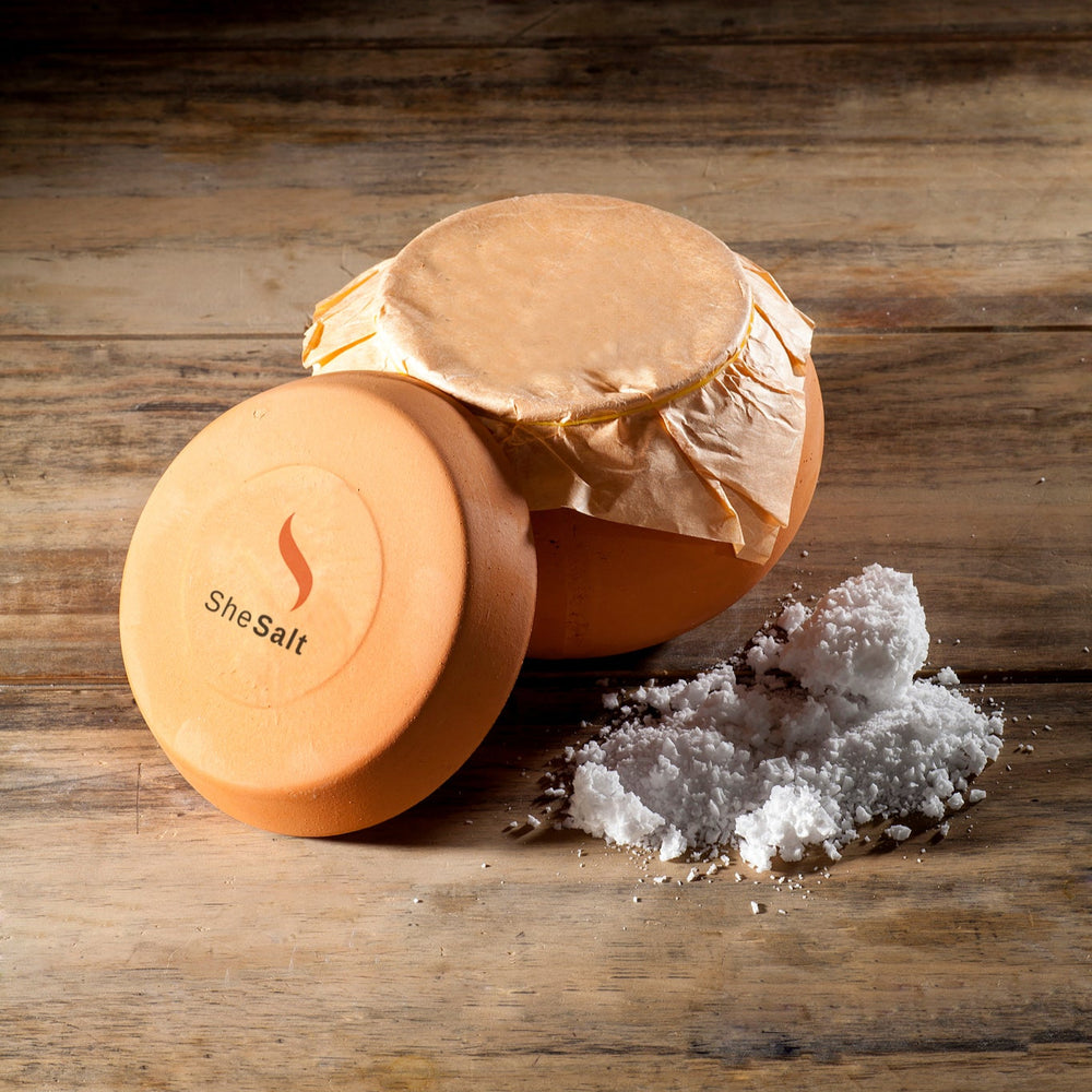 
                  
                    Two containers of SheSalt on a wooden surface with salt crystals beside them.
                  
                